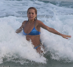 Rita Ora displays her slender physique as she frolics in the surf ...