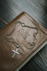 Silver Cross Pendant Necklace on Brown Holy Bible · Stock Photo