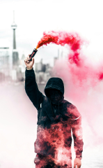 Person wearing black and red hoodie holding smoke bomb photo ...