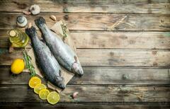 Raw sea fish salmon on old paper with lemon slices and fragrant ...